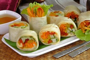 Hummus Veggie Wrap with colorful fresh veggies on a wooden board
